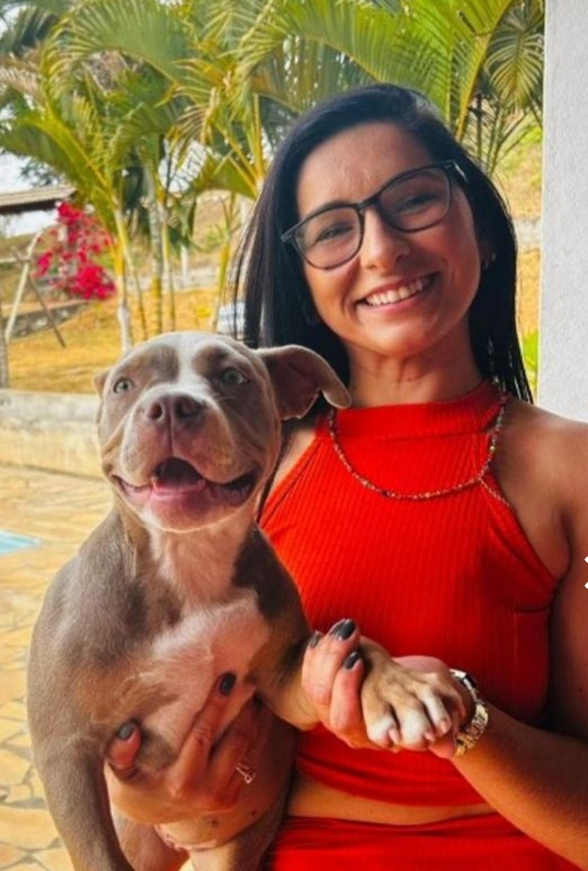 Mulher sorridente com cão ao colo
